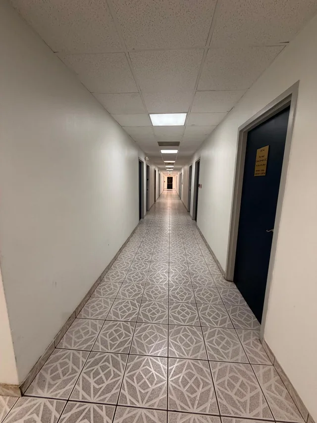 Pasillo interior con puertas de oficinas numeradas